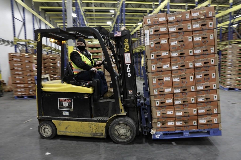 Forklift operator moving a loaded pallet
