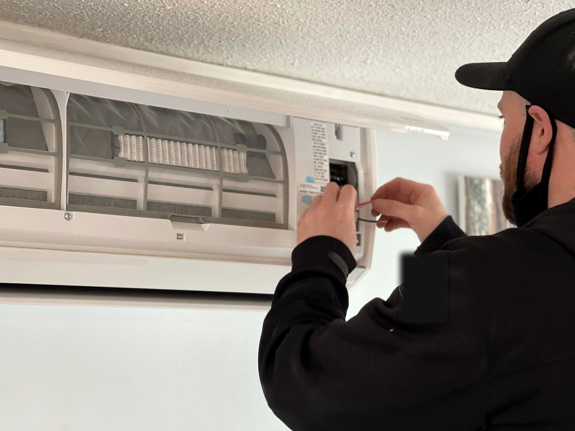Monteur bedraadt binnen een wandmodel split-unit